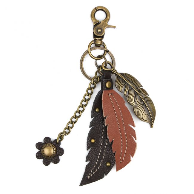 CHALA Charming Feather Keychain, Purse Charm. Conveniently small, fun, and functional. Hold your keys with style! Antique bronze toned Feather key chain. Comes with bonus faux leather flower and feathers. Easy to attach onto a bag, luggage, or keys! Materials: Metal, Vegan Leather.