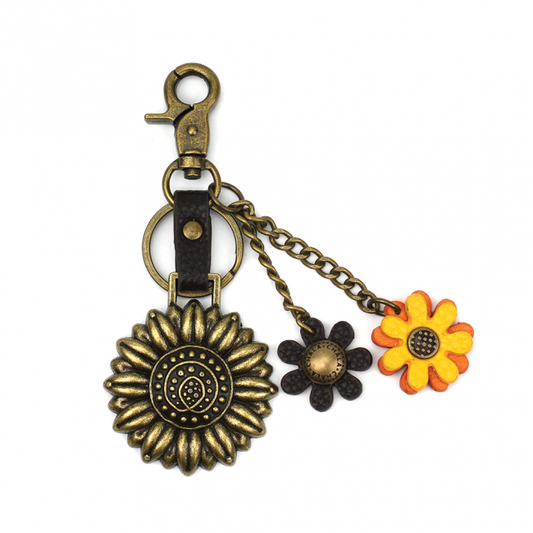 Conveniently small, fun, and functional. Hold your keys with style! Antique bronze toned Sunflower key chain. Comes with bonus flower leather charms. Easy to attach onto a bag, luggage, or keys! Materials: Metal, Vegan Leather. The perfect gift for sunflower and nature lovers.