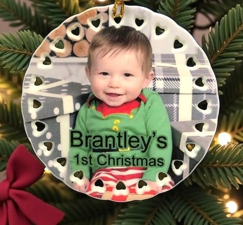 Decorative ornament with a baby's first Christmas design on a tree.