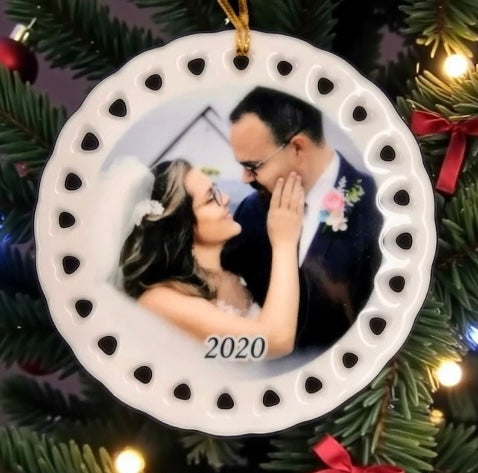Decorative ornament with a couple's photo and '2020' on a Christmas tree.