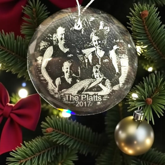 Decorative Christmas ornament with engraved photos and 'The Platts 2017' text on a tree.