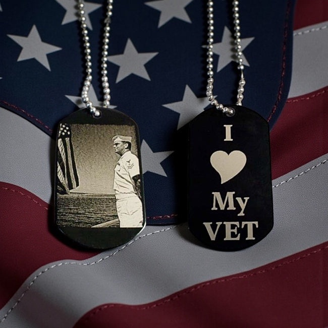Two dog tags on an American flag background, one with a photo of a sailor and the other with 'I ❤️ My VET' text.